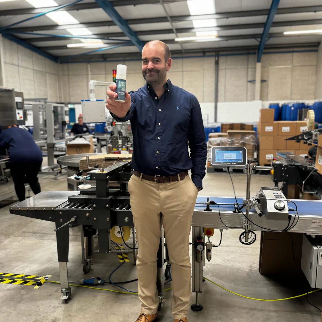 Thomas Laird, MD of Salt of the Earth, holding Ocean & Coconut natural deodorant spray at the end of production line