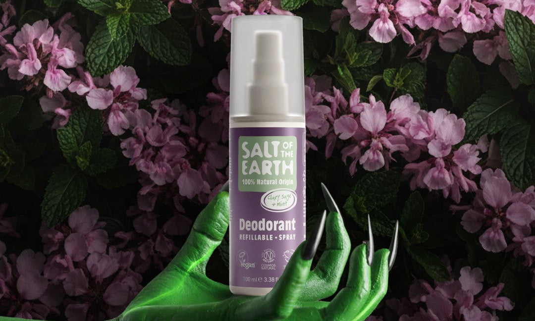 Halloween-themed image showing Salt of the Earth Sage & Mint natural refillable deodorant spray held by a green hand among purple flowers, promoting the ‘SUPERnatural’ deodorant campaign.