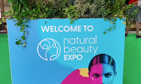 Empty Salt of the Earth natural deodorant exhibition stand F20 at Natural Beauty Expo before setup, showing the white shell scheme booth with blue branded header panels.